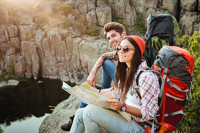 Intimate relationship couple hiking and looking at a map together